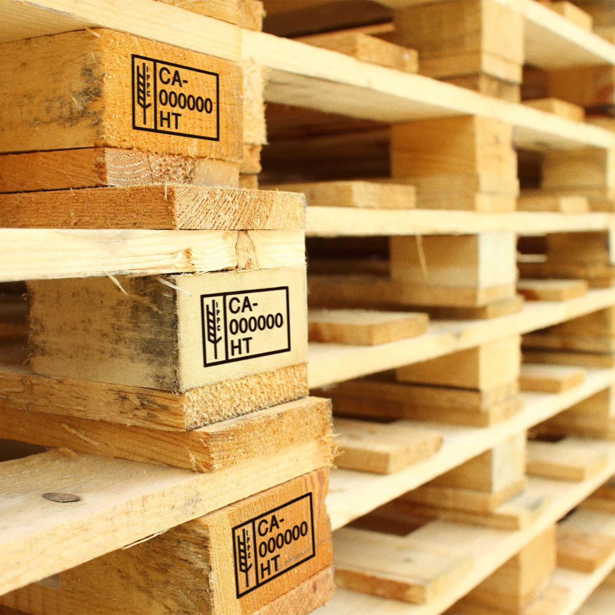 Marked wooden pallets stacked in a warehouse
